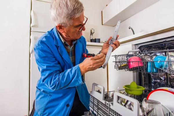 Olgun tesisatçı onarım bulaşık makinesi onun araçları ile — Stok fotoğraf