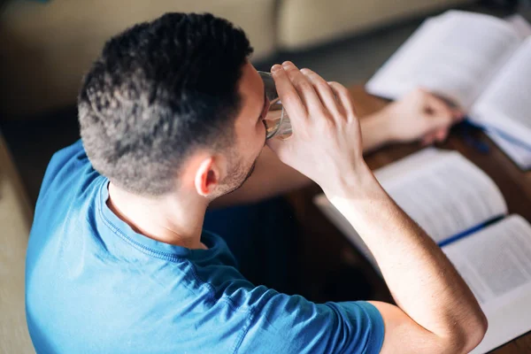 Joven Haciendo Agua Potable Mientras Estudia — Foto de Stock