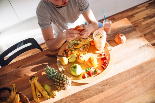 Jeune homme faisant smoothie sur une table par une journée ensoleillée . — Photo