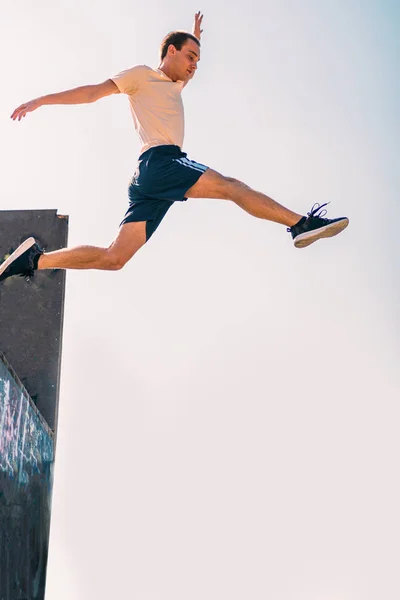 Sportowy człowiek zrobić sztuczki parkour podczas skoków — Zdjęcie stockowe