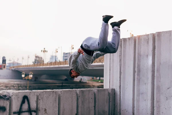 Jóvenes practicando parkour en el parque de la ciudad, haciendo trucos y j. —  Fotos de Stock