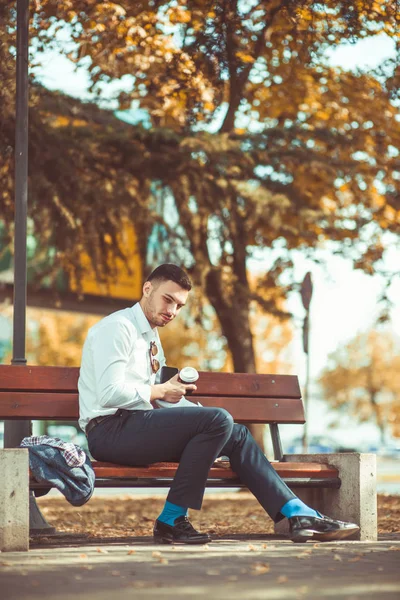 Der moderne Geschäftsmann sieht müde aus und sitzt auf einer Bank — Stockfoto