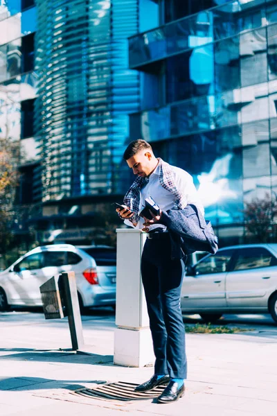 Joven hombre de negocios está caminando en el centro de la ciudad con su noteboo —  Fotos de Stock