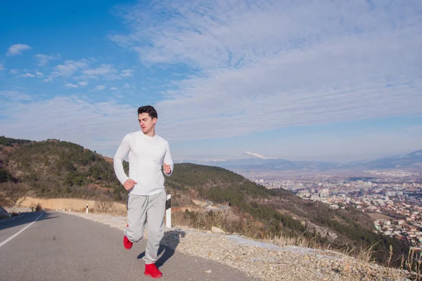 在阳光明媚的日子里, 适合的人在空荡荡的街道上跑下来. — 图库照片