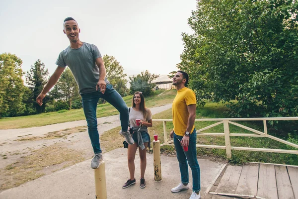 Duas Pessoas Segurando Seus Amigos Que Estão Cerca Ponte Divertindo — Fotografia de Stock