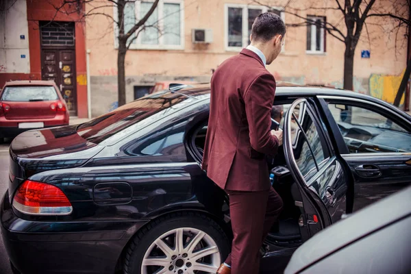 Homem terno entra em uma limusina de negócios — Fotografia de Stock