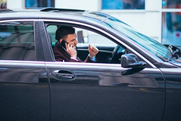 En seriös affärsman är att ha en konversation på sin telefon whil — Stockfoto