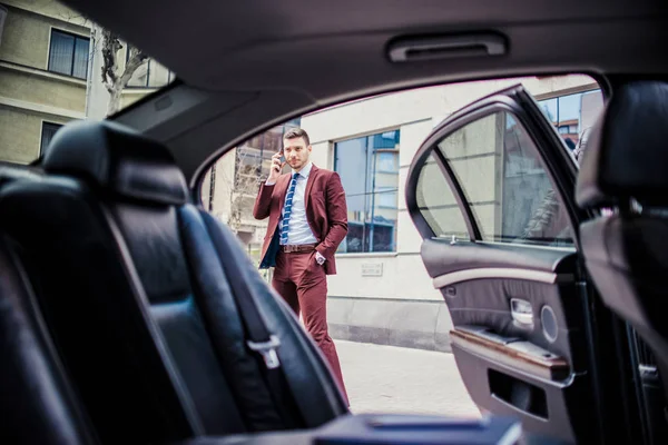 Homem de negócios rico dirigindo em uma limusina e falar em um telefone — Fotografia de Stock