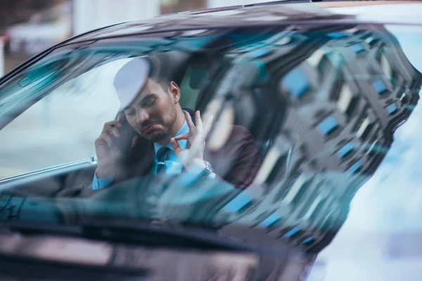 Hombre de negocios serio sentado en el asiento delantero en su limusina en una b — Foto de Stock