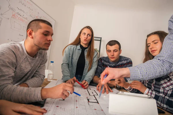 Um grupo de jovens empresários discutindo seu próximo projeto em — Fotografia de Stock