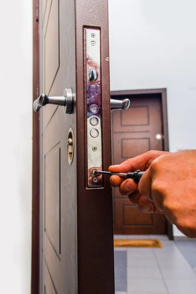 Workman standing near the door and fixing it — Stok fotoğraf