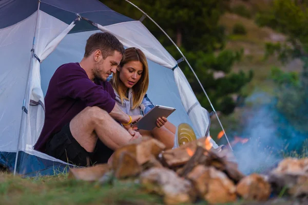 Jovem casal desfrutando da vista da montanha e verificando o tablet — Fotografia de Stock