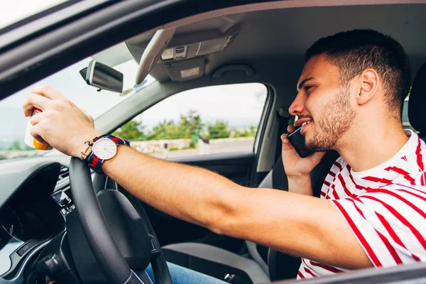 Chico teniendo conversación en su teléfono mientras conduce — Foto de Stock