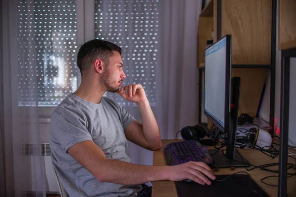 Selbstbewusster Kerl, der am PC im Zimmer arbeitet — Stockfoto