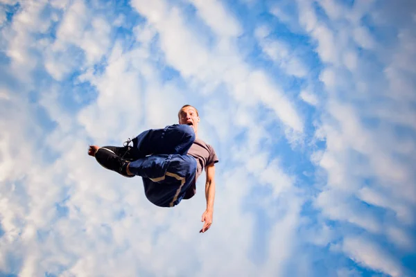 Homem caucasiano saltar alto no ar enquanto fazendo parkour — Fotografia de Stock