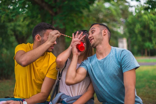 Trois personnes assises sur un banc de parc — Photo