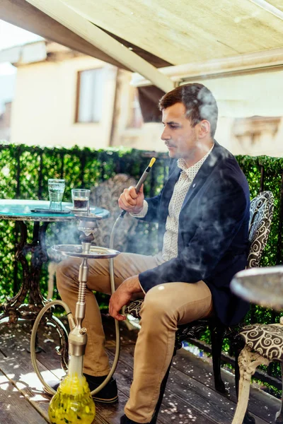 Joven hombre de negocios fumando narguile en balcón —  Fotos de Stock