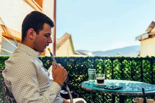 Joven hombre de negocios fumando narguile en balcón —  Fotos de Stock