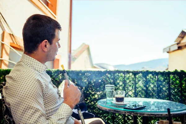 Jungunternehmer raucht Wasserpfeife auf Balkon — Stockfoto