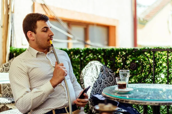 Homme urbain avec téléphone portable et narguilé au balcon — Photo