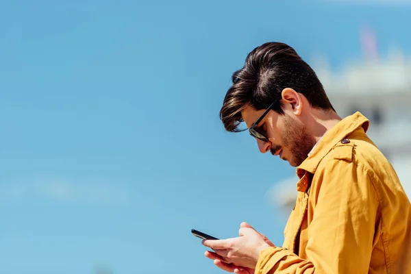 Homme d'affaires sur le téléphone tapant un message texte dans la rue de la ville — Photo