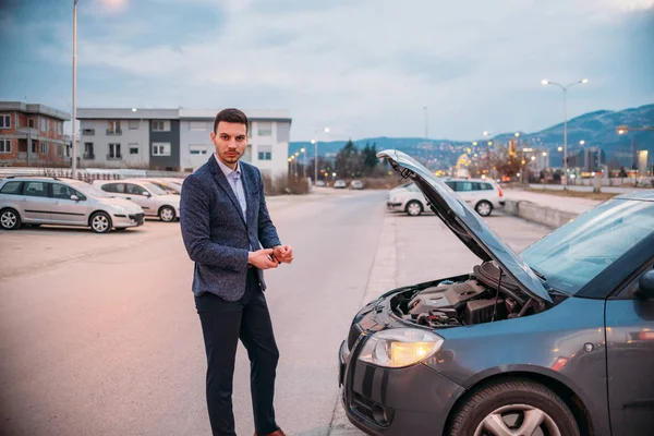 En trött arbetare står bredvid hans bil som formellt klädd och — Stockfoto