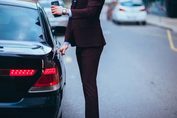 Empresários adequados abrindo a porta das traseiras de sua limusina — Fotografia de Stock