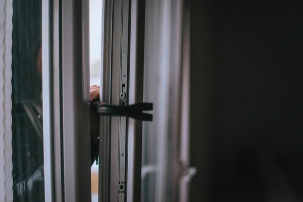 Hooded man with crowbar entering into house — Stock Photo, Image