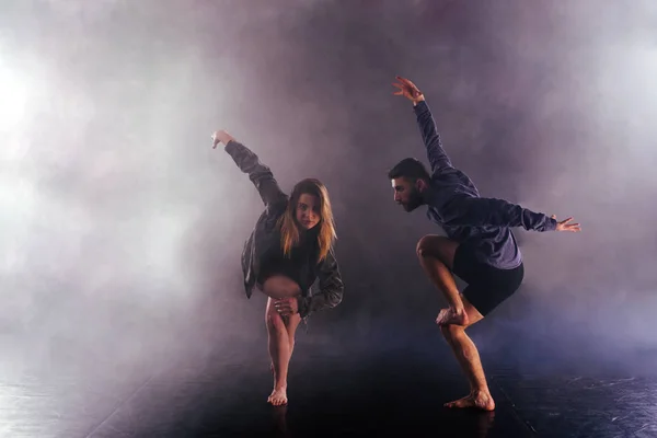 Dos bailarines modernos estiran sus pies sin zapatos alto en el ai —  Fotos de Stock