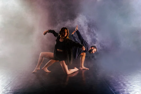 Pareja de danza moderna torciendo sus piernas y lening cerca de la —  Fotos de Stock