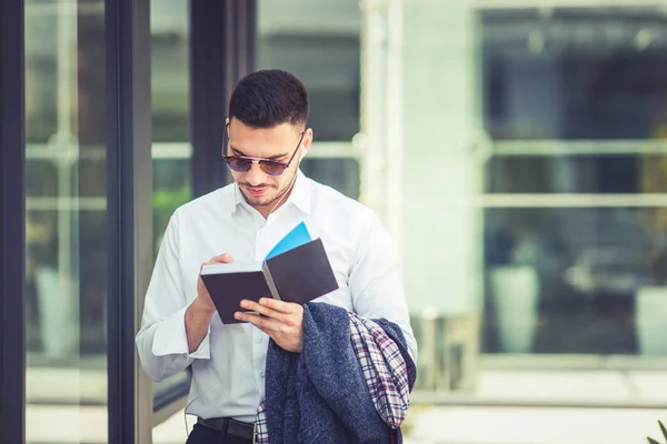 Moderner junger Geschäftsmann steht und liest ein Buch — Stockfoto