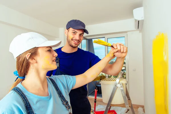 Young married couple having fun while painting living room — Stock Photo, Image