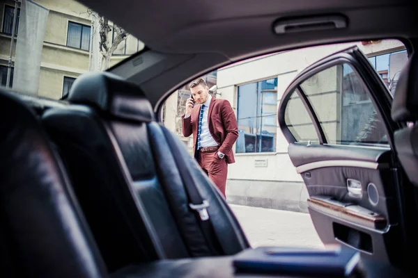 Empresario en traje púrpura hablando por celular afuera — Foto de Stock