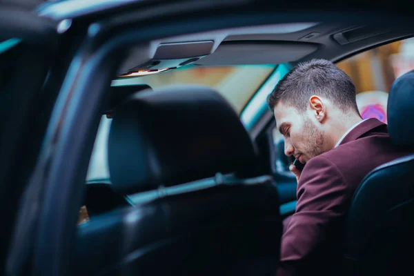 Un hombre de negocios serio está teniendo una conversación en su teléfono mientras — Foto de Stock