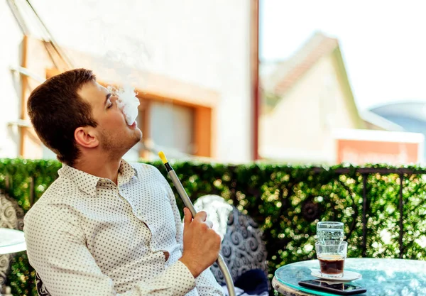 Geschäftsmann chillt auf Balkon, während er Shisha raucht — Stockfoto