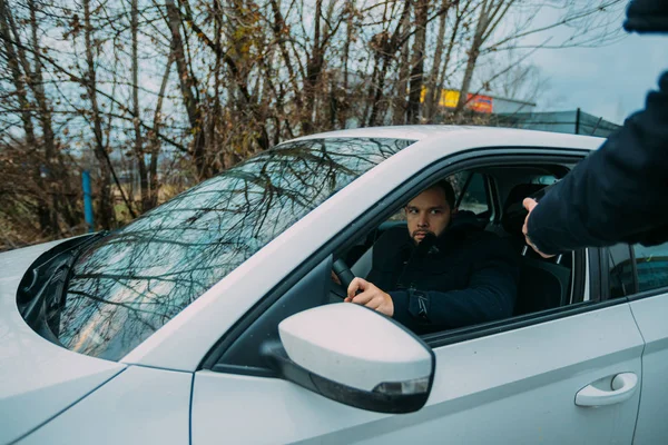 Carjacker atacando agresivamente a un propietario de coche con un arma, tratando de — Foto de Stock