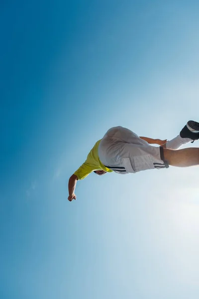Joven haciendo trucos mientras salta en el aire —  Fotos de Stock