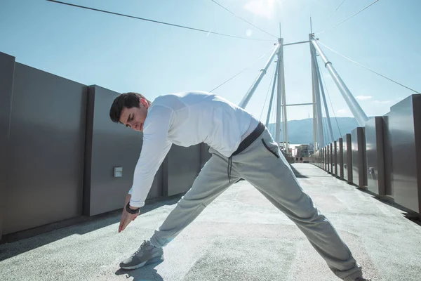 Jovem jogger masculino que se estende ao ar livre — Fotografia de Stock