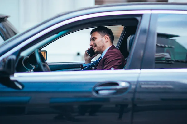 Ein Manager, der auf dem Beifahrersitz seiner Limousine sitzt und auf seinem — Stockfoto