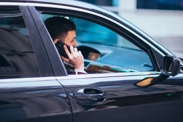 En seriös affärsman är att ha en konversation på sin telefon whil — Stockfoto