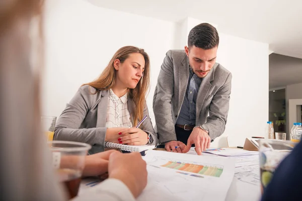 Negocios masculinos y femeninos sentados en una mesa de negocios buscando —  Fotos de Stock