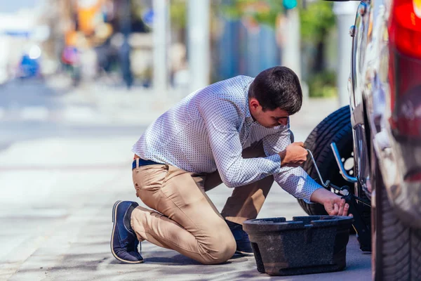 Um homem de negócios forte está dobrando o joelho enquanto tenta mudar — Fotografia de Stock
