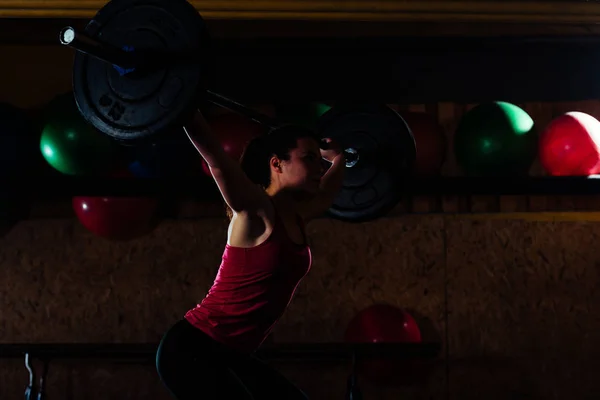 Jovem ajuste menina levantando barbell — Fotografia de Stock