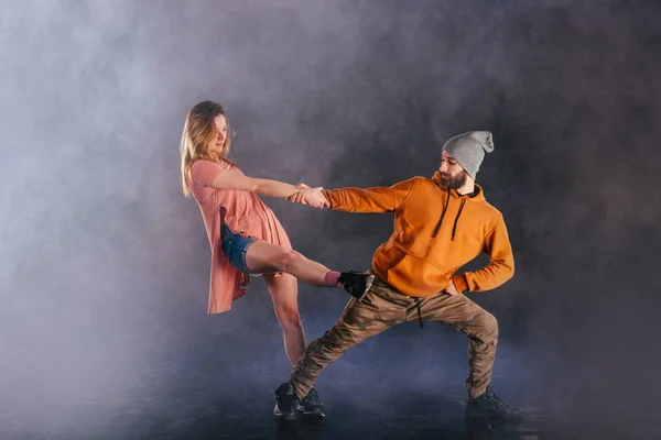 Couple dancing modern dance and showing off their leg stretch mo