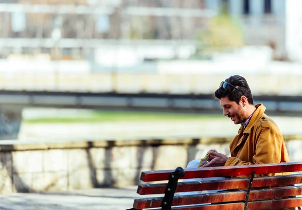 Eleganter Geschäftsmann sitzt im Park — Stockfoto