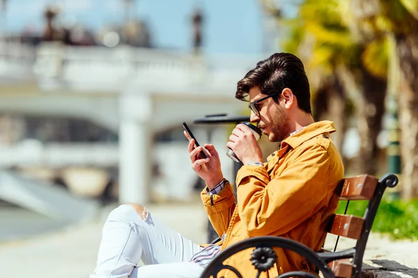 Kentli işadamı telefonuna bakıyor — Stok fotoğraf