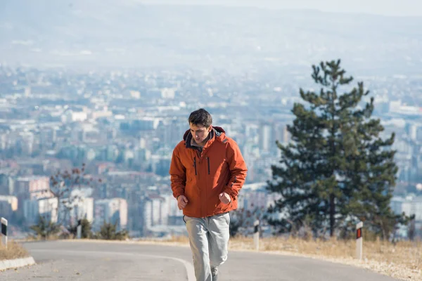 Fit man i sportkläder jogging på berget — Stockfoto