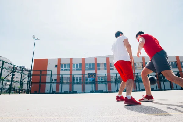 Dos amigos caucásicos con equitación deportiva roja jugando basket —  Fotos de Stock