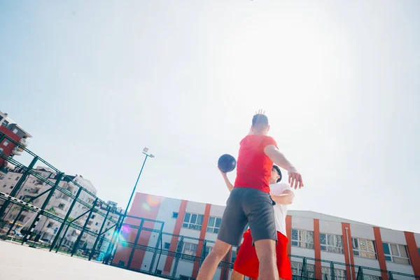 Twee Kaukasische vrienden dragen rode sport equpment spelen mand — Stockfoto