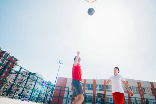 Dos amigos caucásicos con equitación deportiva roja jugando basket —  Fotos de Stock